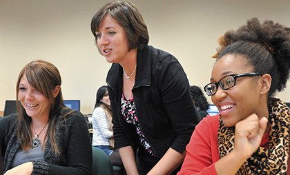 professor assisting two students in class