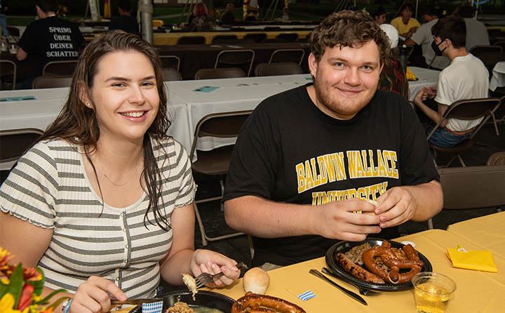 Photo of Two Students Enjoying Food at BW German Club Oktoberfest 
