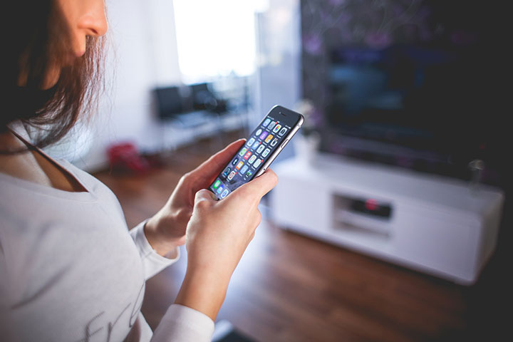 Woman holds mobile phone with privacy risk