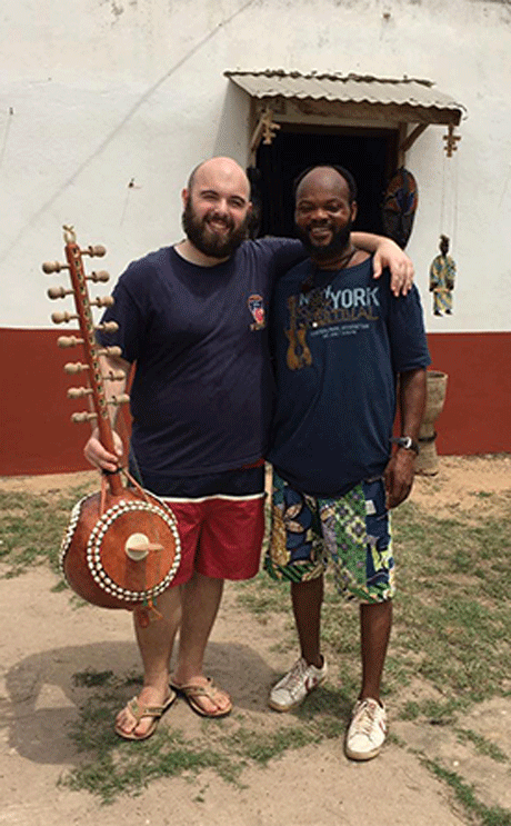 Tyler Hawes stands with his Ngoni and Ghanaian musician