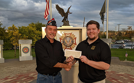 Tad Brown, left, vice Commander of the VFW Post 3345, presents a donation to fund BW's military challenge coins to Caleb Johnston, president of BW's Student Veteran Association (SVA).