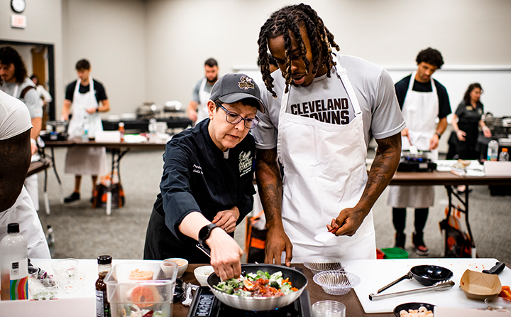 BW dining supervisor Julia Fathauer (l) assists Browns rookie cornerback Martin Emerson (r).