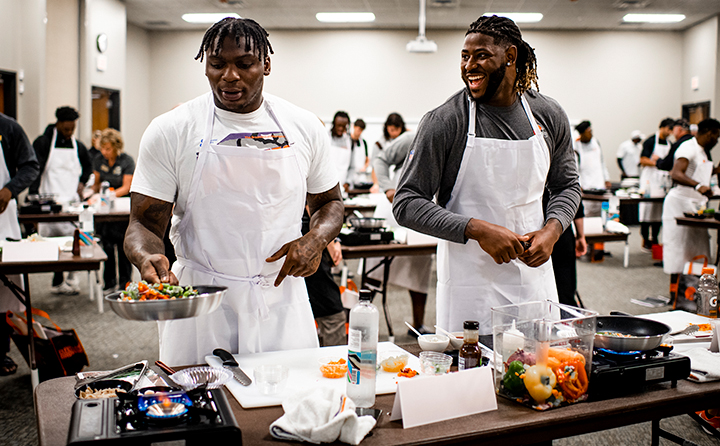 Defensive tackle Perrion Winfrey (l) and defensive end Alex Wright (r) heat up their stir fry stations at BW.