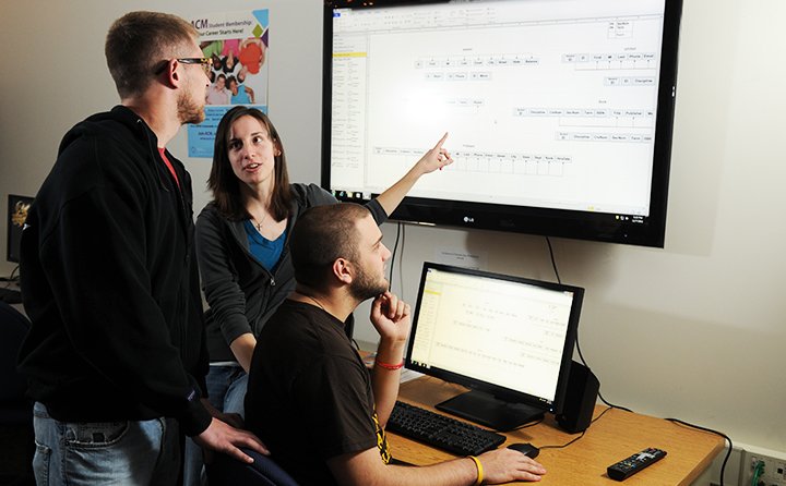 Three computer science major students work together as a group.