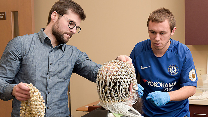 Photo of professor mentoring students in cognitive lab.