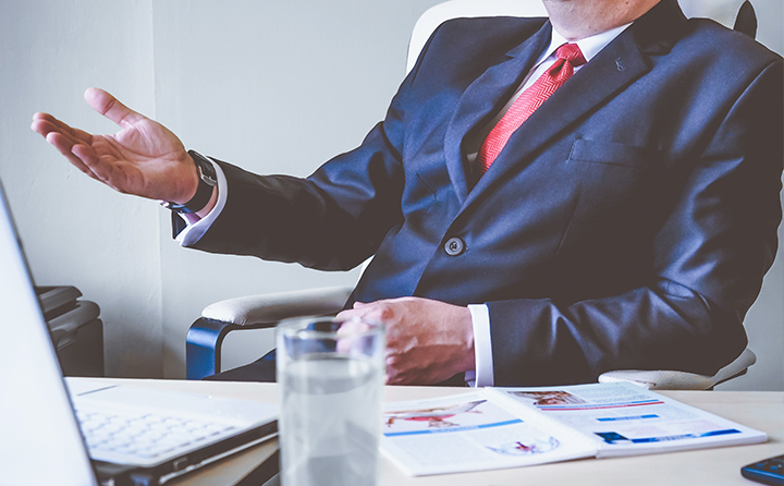 Photo of man in suit behind a desk