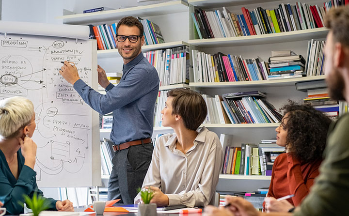 Enlightened leadership professional pointing at a whiteboard