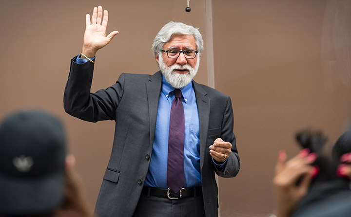 Photo of BW Professor Raising Hand in Front of Class