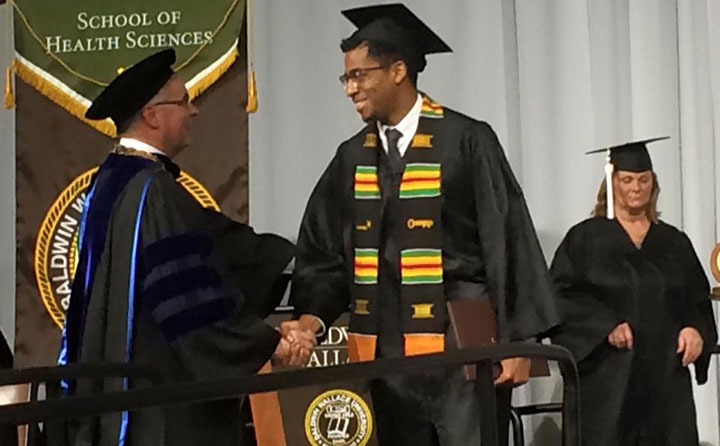 Samuel McIntosh congratulated by BW President Robert Helmer at his commencement