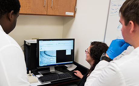 photo of neuroscience student Patrick Woller and Brandon Garrison with Dr. Jackie Morris