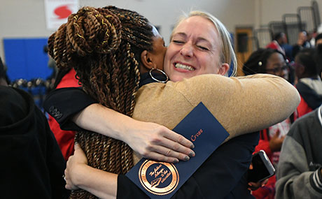  Theresa Cross gets a congratulatory hug from a colleague.