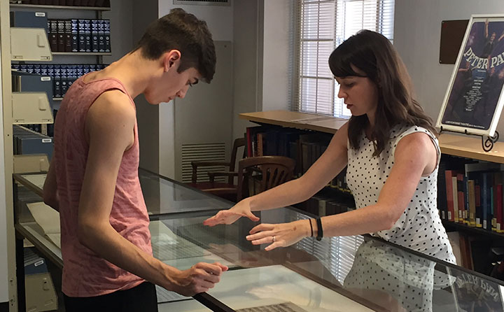 RBI Scholar-in-Residence Dr. Danielle Kuntz discusses an exhibit with a student during a RBI open house.