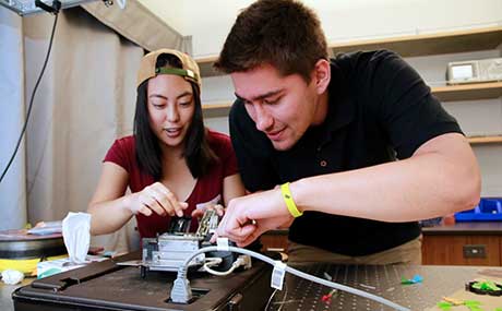 Austin Conn (r) and Kimberly Belmes (l) working with fiber optic cables at the University of Oregon.