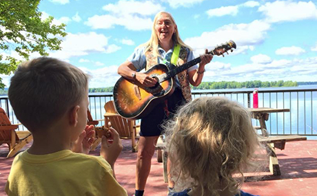 Lalene Kay playing the guitar with children