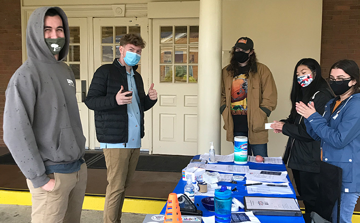 Members of the Jackets Engaged team celebrate with a first-time voter at a campus registration drive in fall 2020.