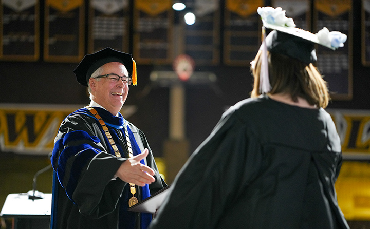 President Bob Helmer congratulates a Fall 2022 graduate