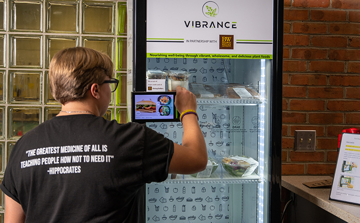 Student buys food from Vibrance kiosk at BW