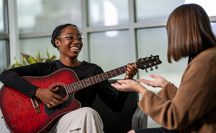 Photo of Music-Therapy student Payton Cole playing guitar