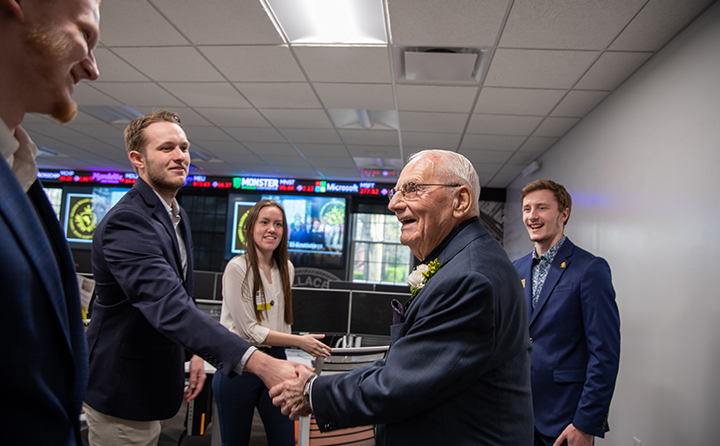 Bill Carmel (right) greets current BW business students in Kamm Hall during the naming event.