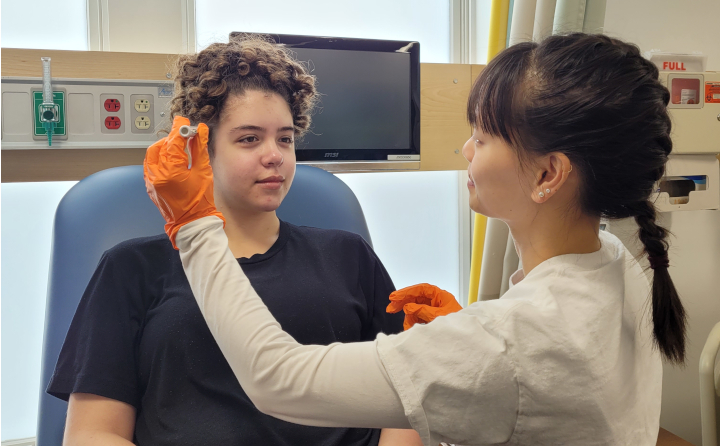 Nursing student Van Lau practices examination skills with acting student Kaitlin Smith.