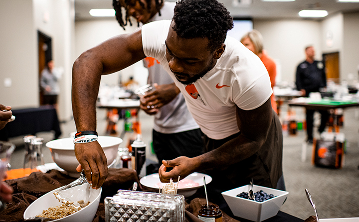 Running back Jerome Ford rims his glass in the decorative dessert competition.