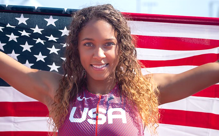 photo of BW alumna Melanie Winters in USA uniform with a flag