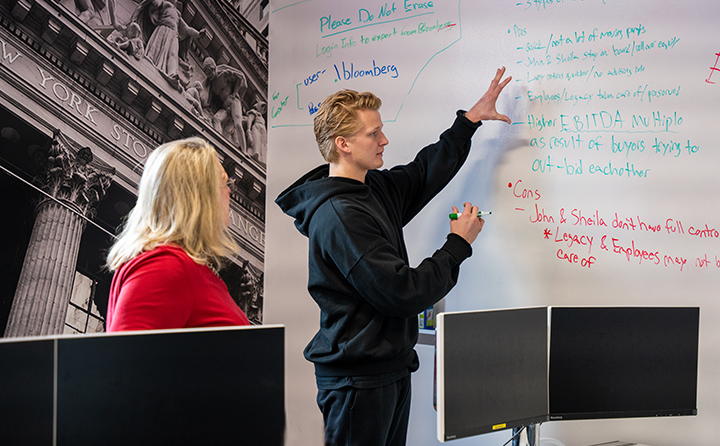 The youngest member of the 2023 ACG Cup team Dane McNulty ’24 (right) talks through the ACG project with the Carmel Boyer School of Business dean Dr. Susan Kuznik (left) in BW’s Business Research Center.