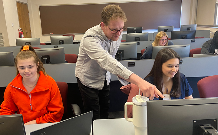 Dr. Andrew Dohanos points to a research point in his BW Quantitative Communication Research II course.