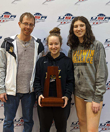 BW racquetball coach Andy Hawthorne (left) poses with his national champion women's doubles team and their team trophy.