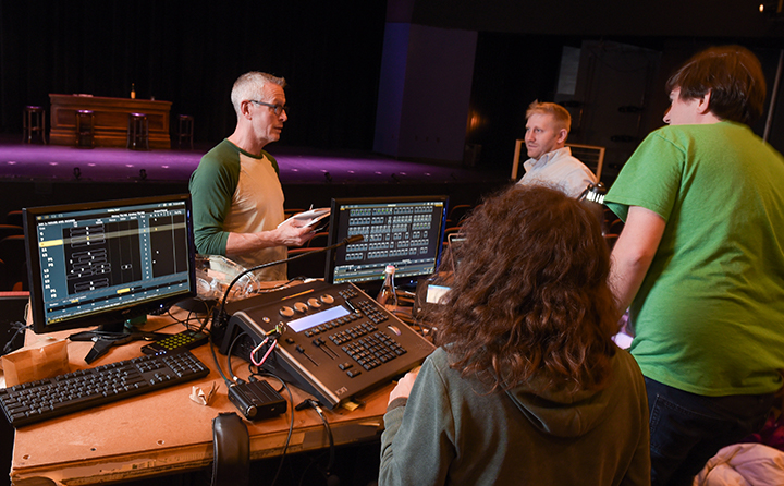 A BW professor works with students in the theatre