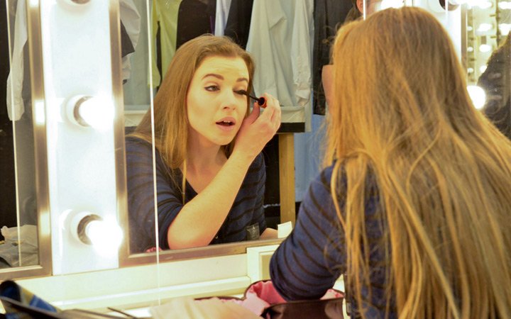 Music Theatre student applying makeup 