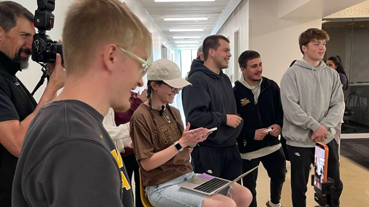 Students recording or producing short-form video content, setting up equipment and collaborating to create social media posts for a client campaign.