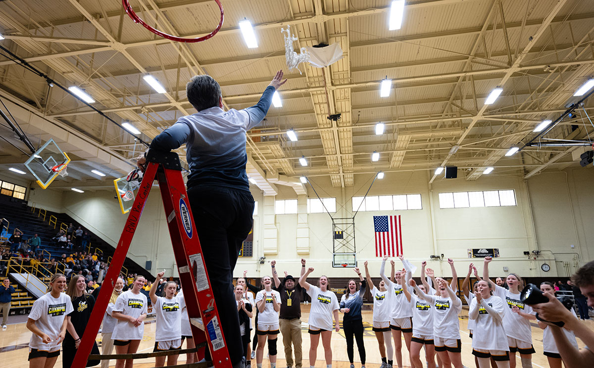 Head Coach Cheri Harrer cuts the net after leading the Yellow Jackets to victory. 