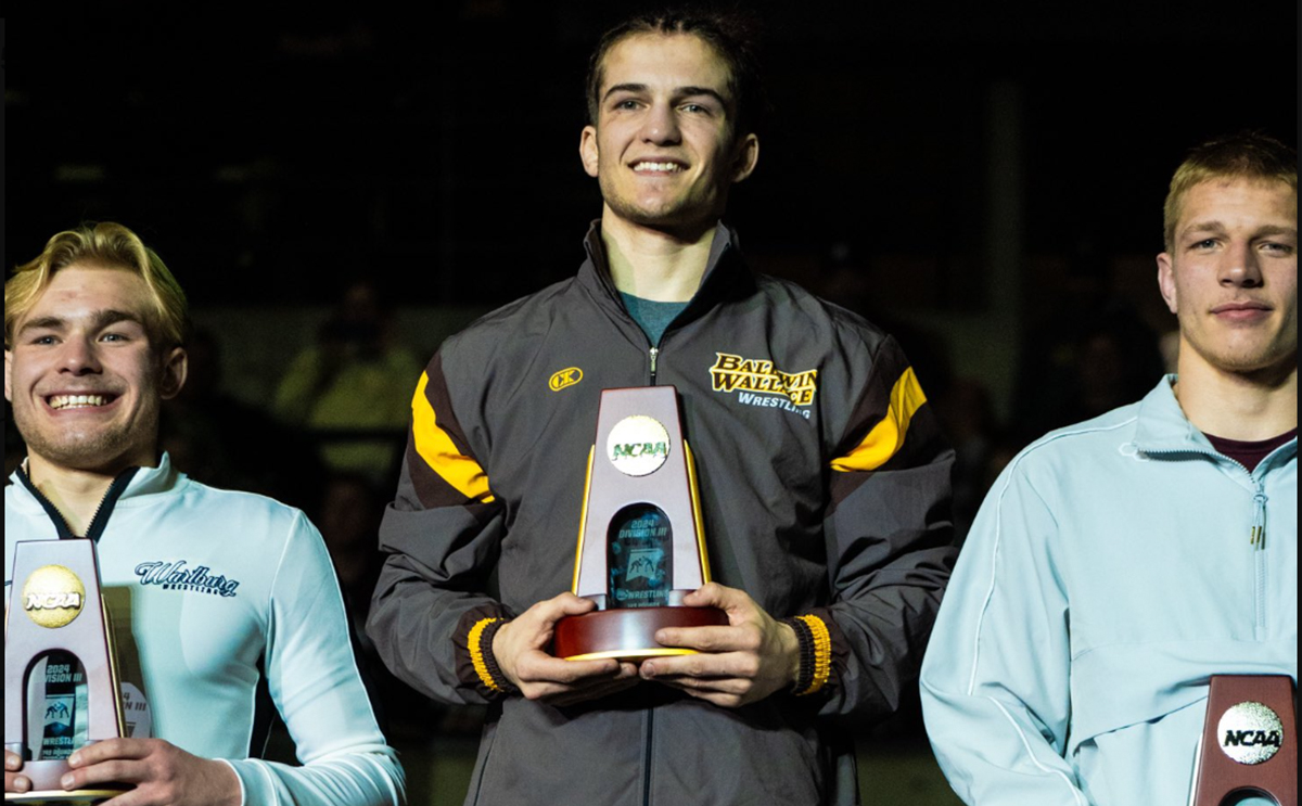 Michael Petrella holding wrestling trophy